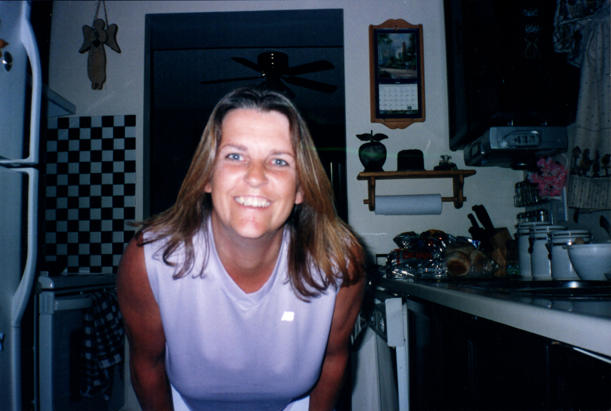 Mom in the kitchen at home, most likely smiling at one of the kids taking her picture.